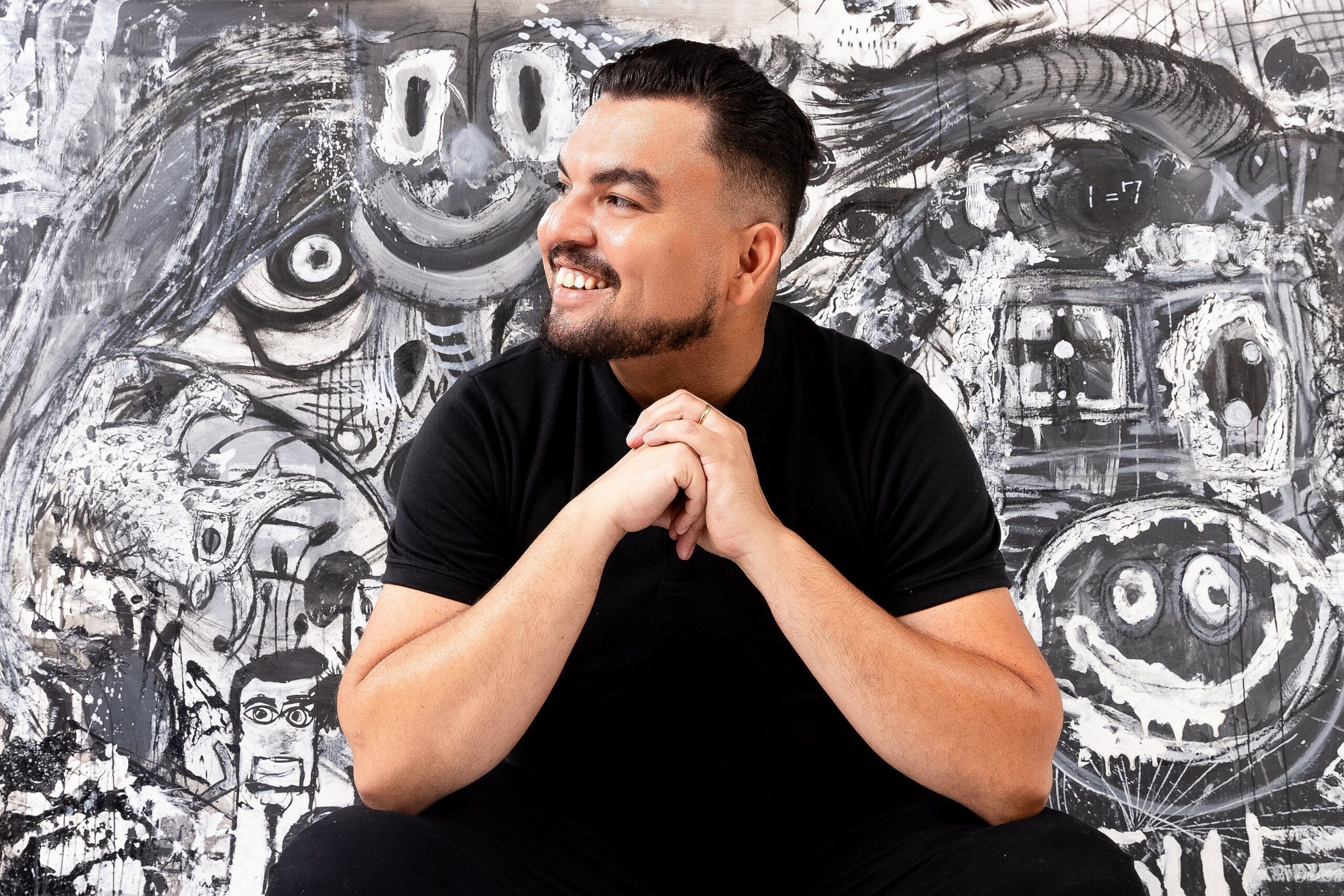 Douglas Gomes diante de uma obra em preto e branco
